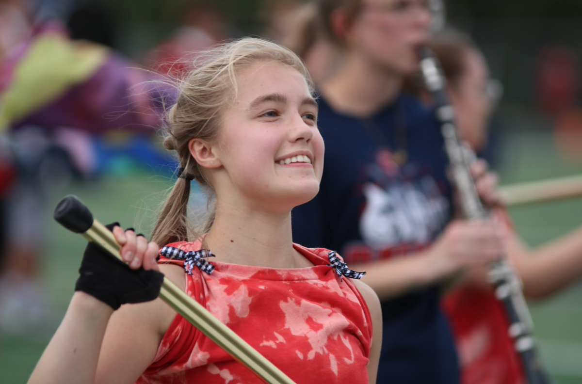 Macy Czech (12) twirling her flag to music during Marching Band.